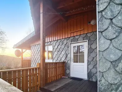 a house with a wooden porch and a white door at 5 person holiday home in LONEVÅG-By Traum in Lonevåg