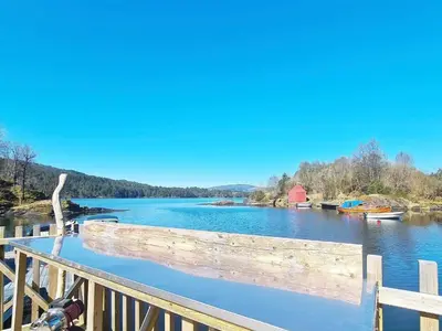 a wooden bridge over a river with boats on it at 5 person holiday home in LONEVÅG-By Traum in Lonevåg