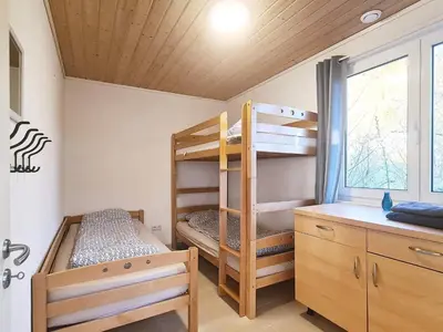 a bunk bed room with two bunk beds and a desk at 5 person holiday home in LONEVÅG-By Traum in Lonevåg