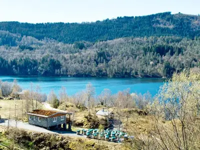 a building on a hill with a body of water at 5 person holiday home in LONEVÅG-By Traum in Lonevåg
