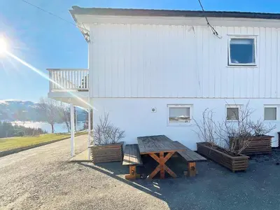 a picnic table in front of a white building at 6 person holiday home in AVERØY-By Traum in Stein