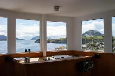 a room with four windows with a view of the water at Fanøy Island Lodge in Fanoyna