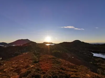 a sunset over the mountains with the sun setting on the horizon at Fanøy Island Lodge in Fanoyna