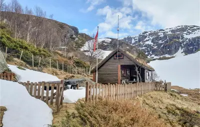a wooden cabin with a flag on a mountain at 4 Bedroom Nice Home In Etne in Etnesjøen
