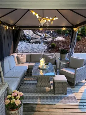 a patio with a couch and chairs and a table at Moderne og sentral leilighet med koselig og privat uteplass! in Hornnes