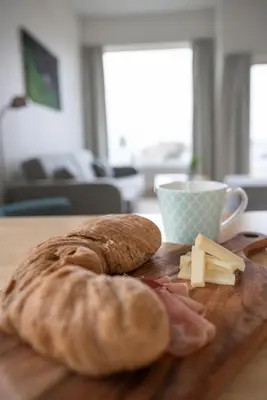 a loaf of bread and cheese on a wooden cutting board at Runde Miljøsenter & Opplev Runde in Runde