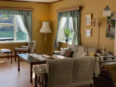a living room with a couch and a table at Svingen Guesthouse - Panoramic Fjord Views in Flåm in Flåm