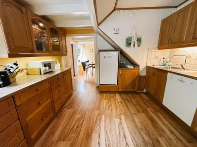 a kitchen with wooden cabinets and a white refrigerator at Svingen Guesthouse - Panoramic Fjord Views in Flåm in Flåm