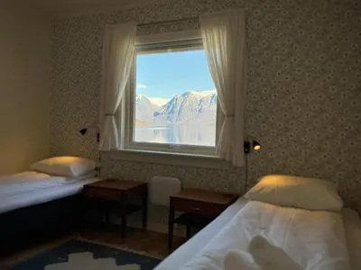a bedroom with two beds and a window with a view at Svingen Guesthouse - Panoramic Fjord Views in Flåm in Flåm