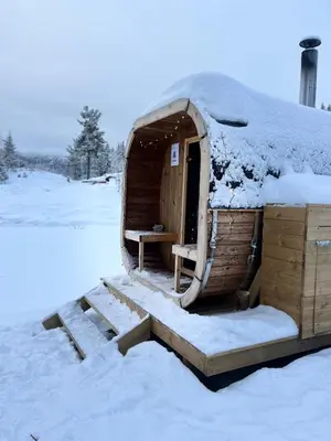a small wooden house with snow on the roof at Vidsyn Midjås in Vistad