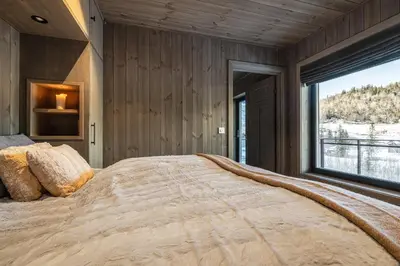a bedroom with a large bed with a large window at Mountain nest in Hemsedal close to the ski slopes in Hemsedal