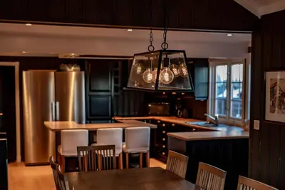 a kitchen with a table and chairs and a chandelier at Storsten 730 in Trysil