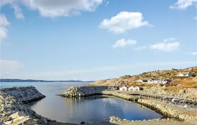 a body of water with houses on a rocky shore at Gorgeous Home In Sveio With Wifi in Sveio