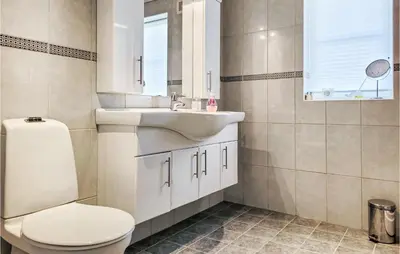a bathroom with a white sink and a toilet at Gorgeous Home In Sveio With Wifi in Sveio