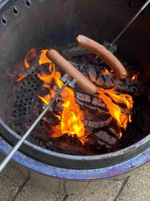 a grill with two hot dogs and fire in it at Roalden Mountain Lodge in Stranda