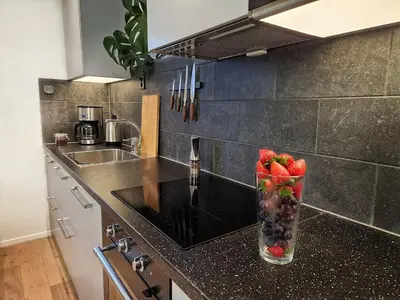 a vase filled with fruit on a counter in a kitchen at Ibsens apartaments in Bergen