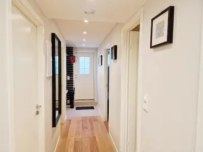 a hallway with white walls and wooden floors at Ibsens apartaments in Bergen