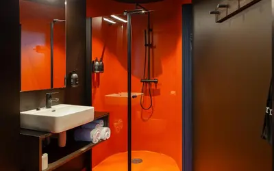an orange bathroom with a sink and a shower at Elva Hotel in Vossevangen