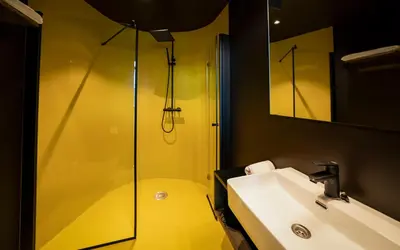 a bathroom with a glass shower and a sink at Elva Hotel in Vossevangen