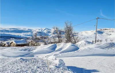 a snow covered mountain with a house in the background at 3 Bedroom Lovely Home In Beitostølen in Beitostøl
