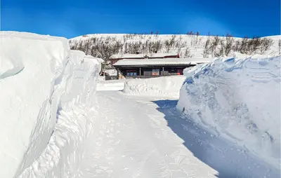 a snow covered road with a building in the background at 3 Bedroom Lovely Home In Beitostølen in Beitostøl