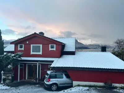 a red house with a van parked in front of it at Line på Hauane1 in Volda