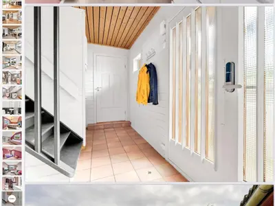 a hallway with white walls and a door and a staircase at Line på Hauane1 in Volda