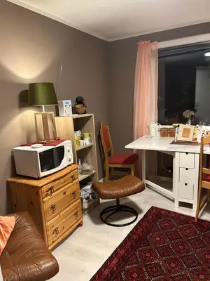 a living room with a microwave on a wooden dresser at Line på Hauane1 in Volda