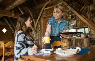 two women sitting at a table with a plate of food at Westerås Gard in Geiranger