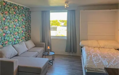 a living room with a couch and a bed and a window at Lovely Apartment In Tisleidalen in Golsfjellet