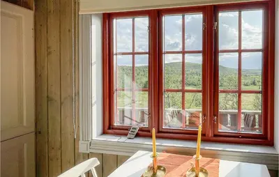 a table with two candles sitting on top of a window at 4 Bedroom Cozy Home In Reinli in Reinli