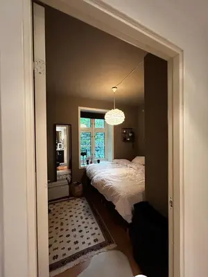 a bedroom with a bed and a window and a chandelier at Modern Apartment in the center of Bergen in Bergen