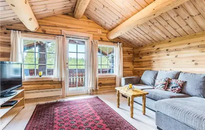 a living room with a couch and a table and a tv at Beautiful Home In Dalholen With Sauna in Furuhovde