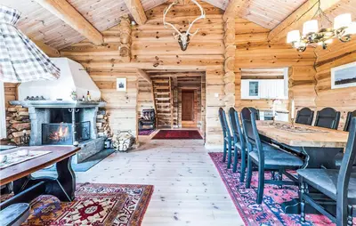 a dining room with a fireplace in a wooden cabin at Beautiful Home In Dalholen With Sauna in Furuhovde