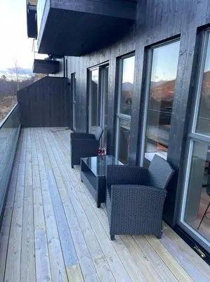 a deck with chairs and a table on a building at Resvegen 63 in Stranda