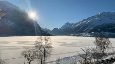 a view of a frozen lake with mountains in the background at Solvik #apartment #Loen in Loen