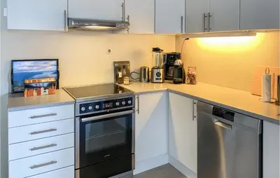 a kitchen with white cabinets and a black oven at Pet Friendly Apartment In Tresfjord in Tresfjord