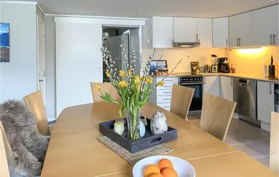 a dining room table with a vase of flowers on it at Pet Friendly Apartment In Tresfjord in Tresfjord