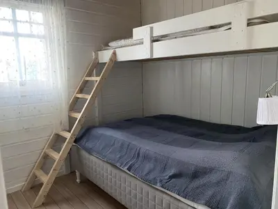 a bedroom with a bunk bed and a ladder at Rosendal Hyttetun in Rosendal