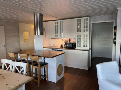 a kitchen with white cabinets and a table and chairs at Rosendal Hyttetun in Rosendal