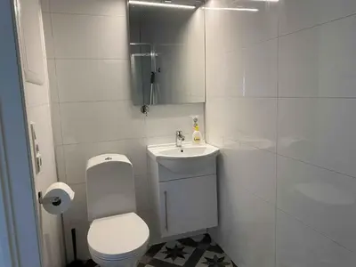 a white bathroom with a toilet and a sink at Rosendal Apartments Motellet in Rosendal