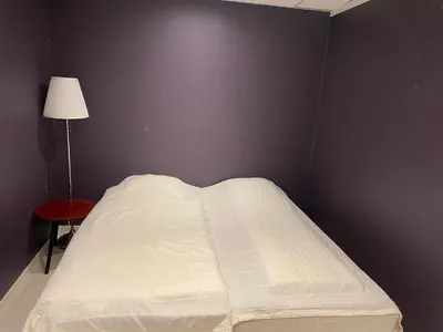 a bed in a corner of a bedroom with a lamp at Rosendal Apartments Motellet in Rosendal