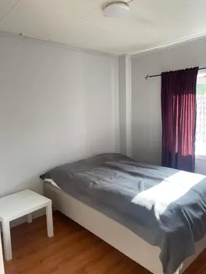 a white bedroom with a bed and a window at Rosendal Apartments Motellet in Rosendal