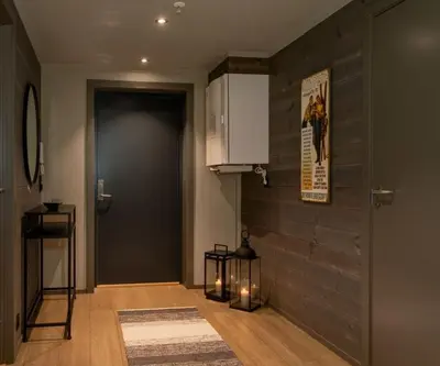 a hallway with a door and a room with a rug at Riddertunet apartment 104 - in the center of Beitostølen in Beitostøl
