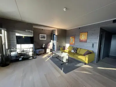 a living room with a yellow couch and a tv at Riddertunet apartment 104 - in the center of Beitostølen in Beitostøl