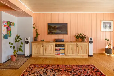 a living room with a wooden cabinet and speakers at Vinjestogo- mesmerizing mountain view, sauna with a view and eco living in an old school house in Løken