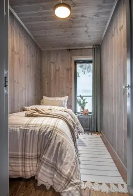 a bedroom with wooden walls and a bed with a window at Exclusive Suite in the Sunnmøre Alps, Near Geiranger & Hjørundfjord in Stranda