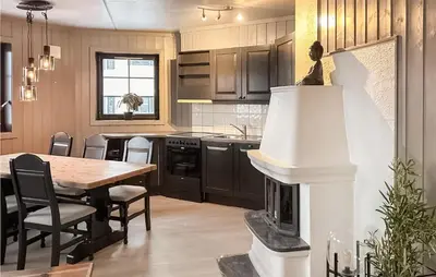 a kitchen with a table and a fireplace in it at Beautiful Apartment In Noresund in Noresund
