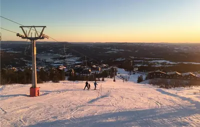 two people skiing down a snow covered ski slope at Beautiful Apartment In Noresund in Noresund