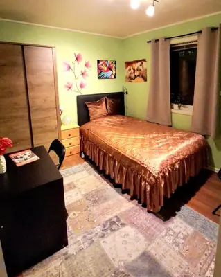 a bedroom with a bed and a table in a room at Gjesterom til leie i et privat hus in Brumunddalen